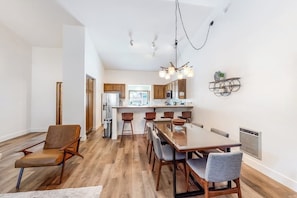 A modern kitchen with wooden cabinets, a central island, and a dining area with a large table and chairs. - Walk to Village & Gondola Corner Condo w/ Fireplace, WiFi & Shared Hot Tub (Mammoth Lakes)
