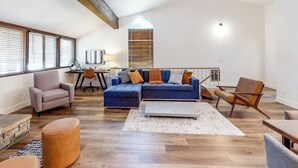 Un'ampia zona giorno con un divano componibile, un tavolino da caffè e un tavolo da pranzo con sedie.