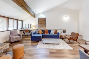 A spacious living area with a large sectional sofa, a coffee table, and a dining table with chairs. - Walk to Village & Gondola Corner Condo w/ Fireplace, WiFi & Shared Hot Tub (Mammoth Lakes)