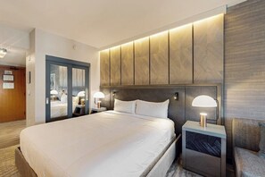 A hotel room with a large bed, bedside lamps, a wooden headboard, and a mirror. - Steps from the Village Gondola w/ Fireplace & Shared Pool/Hot Tub, Dog-friendly (Mammoth Lakes)