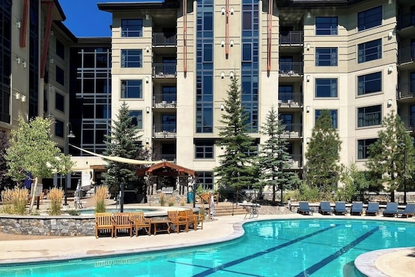 A hotel with a swimming pool, outdoor seating, and a covered patio area. - Steps from the Village Gondola w/ Fireplace & Shared Pool/Hot Tub, Dog-friendly (Mammoth Lakes)