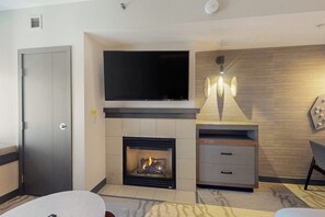 A modern living room with a flat-screen TV, fireplace, and built-in storage unit. - Steps from the Village Gondola w/ Fireplace & Shared Pool/Hot Tub, Dog-friendly (Mammoth Lakes)