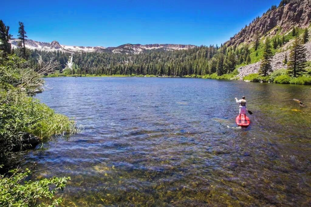 A clear lake surrounded by forested mountains.