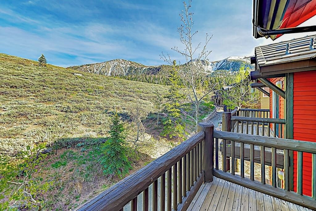 A wooden deck with a view of a mountainous landscape.