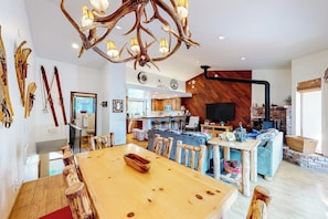 Ein modernes Interieur mit einem Holzesstisch, einem Kamin und einem Fernseher.