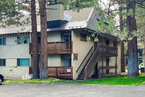 A multi-story building with a balcony, a staircase, and a sign indicating 'Caution Ice.' - Well-located condo with pool, hot tub, sauna, tennis - near golf & slopes (Mammoth Lakes)