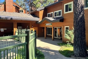 A wooden building with an 'OFFICE' sign, a gated entrance, and a tree. - Home with Views, Shared Pool & Hot Tub - Near the Slopes (Mammoth Lakes)