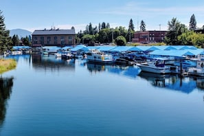 Un port de plaisance avec des bateaux amarrés, un bâtiment doté de grandes fenêtres et un ciel dégagé.