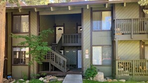 A two-story building with a front entrance, a staircase, and a small porch area. - Condo Near Eagle Lodge & Golf w/ Fireplace, WiFi & Shared Pool/Hot Tub/Sauna (Mammoth Lakes)