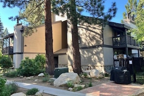 A modern building with a two-story structure, large windows, and a balcony. - Well-equipped mountain-view condo with outdoor pool, hot tub, grill, & fireplace (Mammoth Lakes)