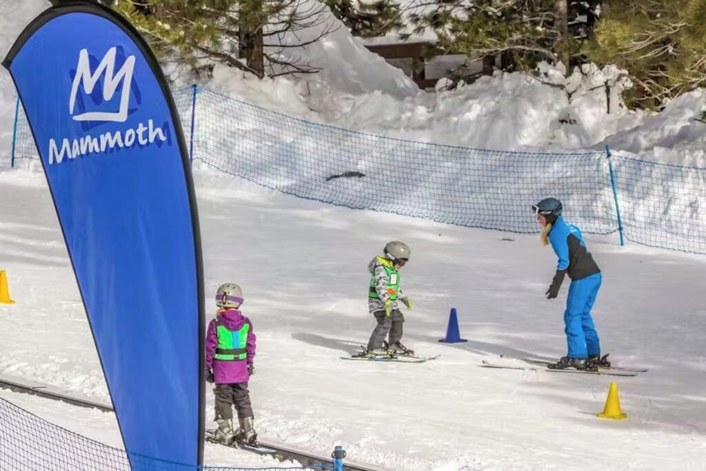 Eine Skipiste mit blauem Banner, einem Netzauslaufgitter und Schneebecher.
