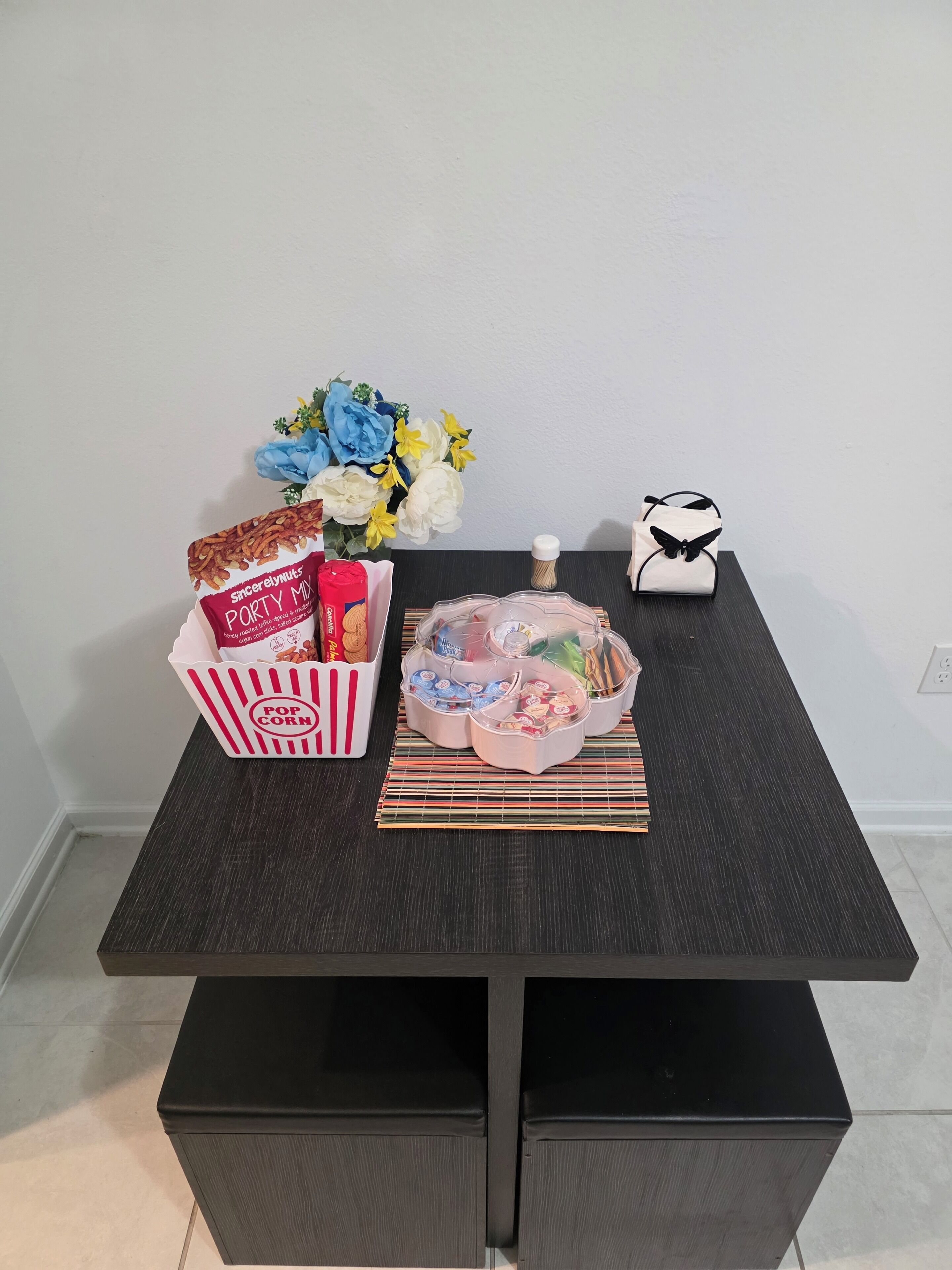 A table with a popcorn container, a cake, and a gift box.