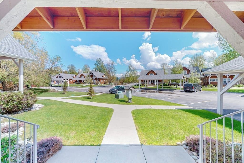 A covered walkway leading to a row of houses with a clear sky and clouds above.