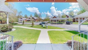 A covered walkway leading to a row of houses with a clear sky and clouds above.