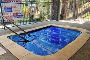 A swimming pool with a lifeguard chair and a safety sign. - All-season condo with hot tub, deck, sauna, wood stove & washer/dryer (Mammoth Lakes)