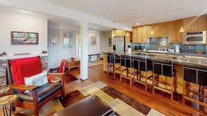 Una cocina moderna con una isla central, armarios de madera y taburetes de bar.