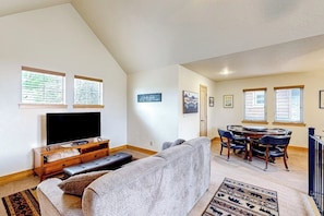 A living room with a television, sofa, and dining area with chairs. - Home with patio, grill, fireplace, streaming, washer/dryer & AC (Dover)