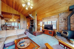 Ein gemütliches Blockhaus-Interieur mit Kamin, Holzmöbeln und einem Fernseher.