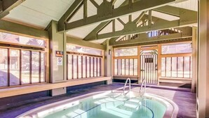 A hot tub with a wooden deck, metal railings, and a no smoking sign. - Lovely mountain-view townhome with hot tub, sauna, & deck views - near skiing (Mammoth Lakes)