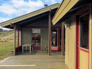 A wooden building with a covered porch, a bench, and a door. - 6 Person Holiday Home in Lokken (Lokken)