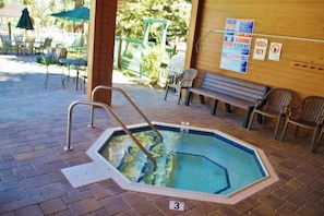 An indoor swimming pool with a wooden deck, a bench, and safety signs. - Cozy condo w/ shared pool, hot tub & sauna, near outdoor activities (Mammoth Lakes)