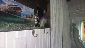 A room with a view of a boat, a small statue, a light switch, and a curtain. - Peaceful 1-bedroom caravan with AC in Mammoth Spring. (Mammoth Spring)