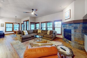 A living room with a sectional sofa, a fireplace, and large windows. - Elegant, newer, 1st-floor condo with private hot tub - steps to resort marina (Dover)