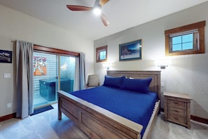 A bedroom with a bed, a ceiling fan, a nightstand, a chair, and a sliding glass door. - Elegant, newer, 1st-floor condo with private hot tub - steps to resort marina (Dover)