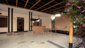 A spacious indoor area with a tiled floor, a reception desk, and a seating area with chairs. - C.H. Santa Cruz  (Cartagena)