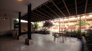An indoor patio area with a tiled floor, a wooden pergola, and outdoor seating. - C.H. Santa Cruz  (Cartagena)