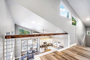 A modern interior with a staircase, a kitchen, and a dining area.