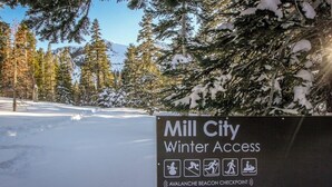 Cartell que indica 'Mill City Winter Access' amb símbols per a raquetes de neu, senderisme i motos de neu.