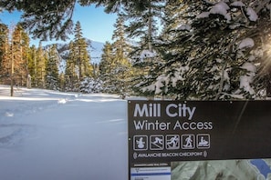 Schild mit der Aufschrift 'Mill City Winter Access' und Symbolen für Schneeschuhwandern, Wandern und Schneemobilfahren.