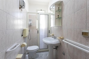 A compact bathroom with a toilet, sink, and shower. - Residence La Pineta - Campsite (Otranto)
