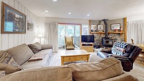 Ein Wohnzimmer mit einer Couch, einem Sessel, einem Couchtisch und einem Kamin.