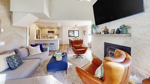 A spacious living area with a sofa, ottoman, leather armchair, and a fireplace. - Updated Condo With Pool and Spa Access, Near Ski Resort, Hiking/Biking Trails (Mammoth Lakes)