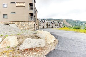 A hotel named Copper Ridge with a stone facade, multiple balconies, and a view of a mountainous landscape.