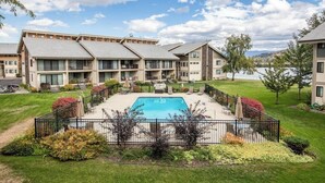 Et hotel med swimmingpool, flere altaner og en velholdt have.