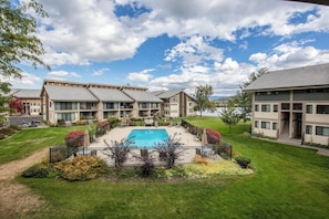 A hotel with multiple buildings, a swimming pool, and a well-maintained lawn. - Waterfront condo w/ complimentary boat slip, shared pool, & sports courts (Sandpoint)