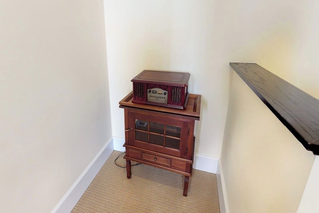 A corner with a wooden cabinet and a radio on top.