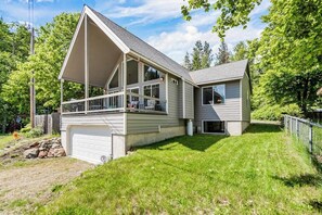 A two-story house with a garage, a covered porch, and a sloped roof.