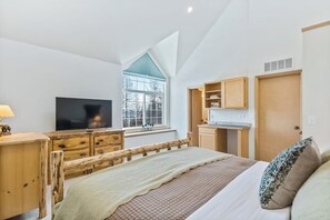 A bedroom with a bed, a TV, a window, and a kitchenette. - Updated Schweitzer Mt. condo w/ gas fireplace, full kitchen, & easy ski access (Sandpoint)