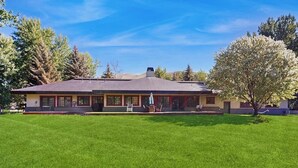 A two-story building with a flat roof, a covered porch, and a well-maintained lawn.