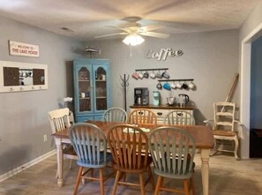 A dining area with a wooden table and chairs, a coffee station, and a blue cabinet. - 25 Sweet Serenity - Weiss Lake (Leesburg)