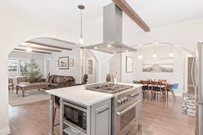 A modern kitchen with a central island, built-in oven, and stainless steel appliances. - Centrally-Located Upscale House with Free WiFi, Porch & Oversized Fenced Yard (Sandpoint)