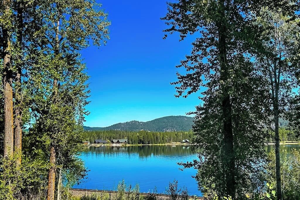 Un lago tranquilo rodeado de árboles y un cielo despejado.
