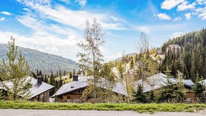 Ein Wohngebiet mit Häusern, umgeben von Grünflächen und Bergen.