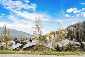 Ein Wohngebiet mit Häusern, umgeben von Grünflächen und Bergen.