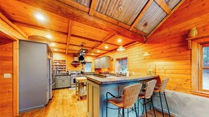 Een houten chalet inrichting met keuken, een bar en zitplaatsen.