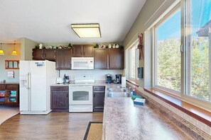 A modern kitchen with a large window, built-in appliances, and a view of the outdoors. - Cozy mountain condo with beautiful ski view - Ski In/Ski Out (Sandpoint)